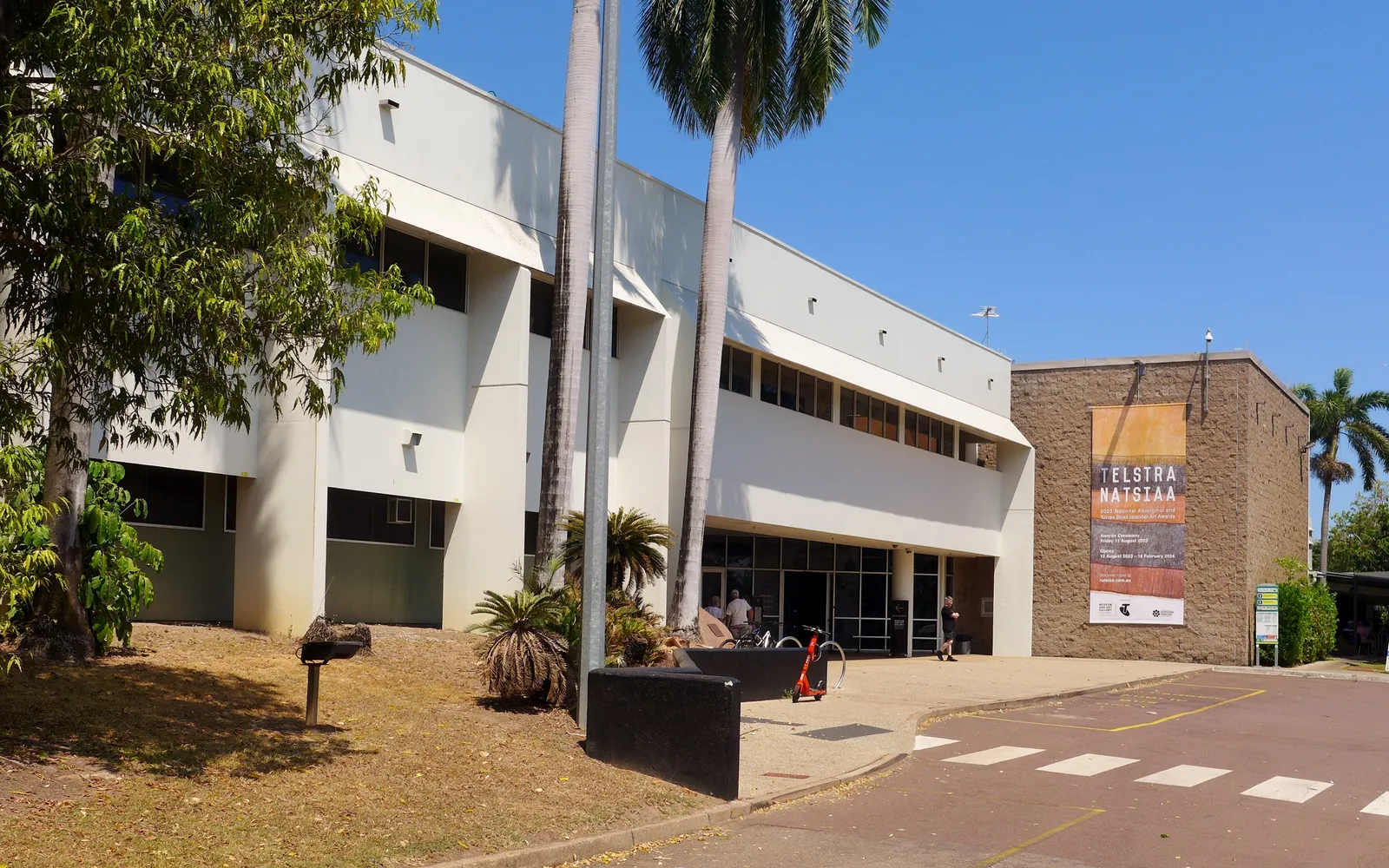ด้านหน้าพิพิธภัณฑ์ Museum and Art Gallery of the Northern Territory ล้อมรอบด้วยสวนสีเขียวและทะเลสีฟ้าเบื้องหลัง
