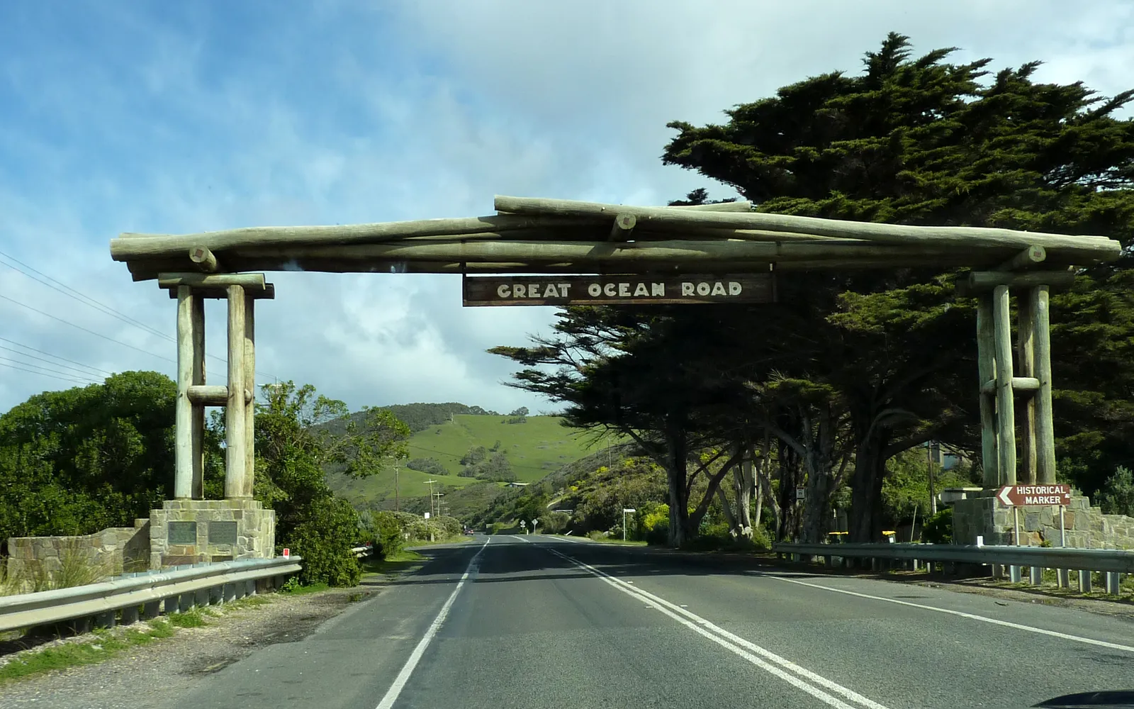 ถนน Great Ocean Road โค้งตัดริมหน้าผาเลียบมหาสมุทรใต้ น้ำทะเลสีฟ้าเข้มตัดกับหินปูนสูงชันสีขาวครีมในแสงเช้า
