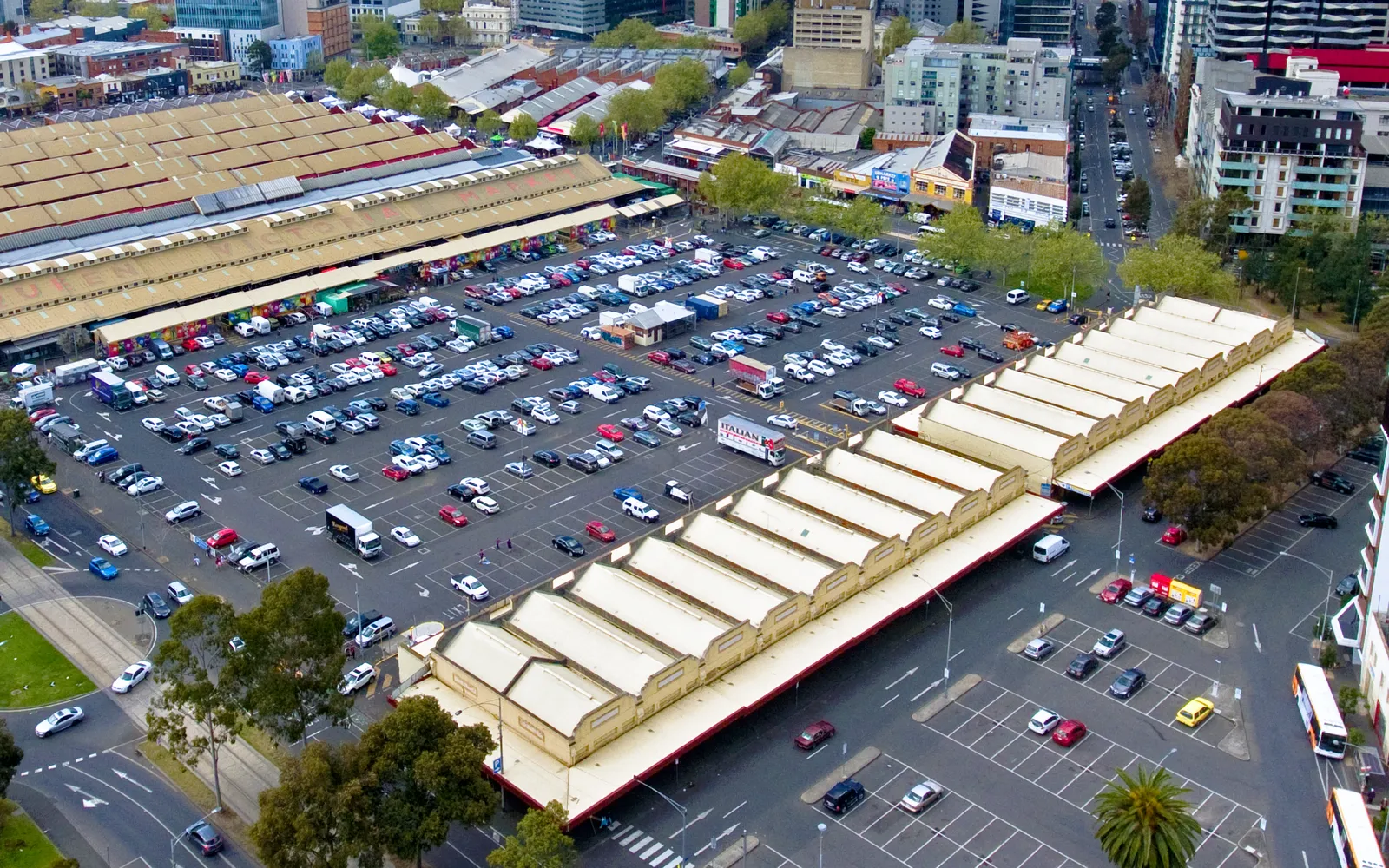 ตลาด Queen Victoria Market เมลเบิร์น อาคารทรงวิกตอเรียนหลังคาเหล็กสีขาวยาวเหยียด แผงขายผักผลไม้และอาหารสดเรียงรายหนาแน่น