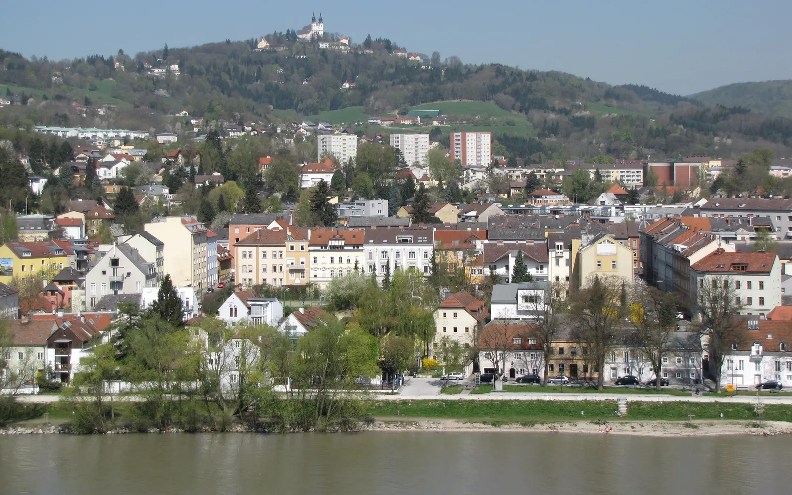 โบสถ์ Pöstlingbergkirche สีขาวสองหอคอยบนยอดเนินเขา Pöstlingberg มองเห็นเมืองลินซ์และแม่น้ำดานูบด้านล่าง