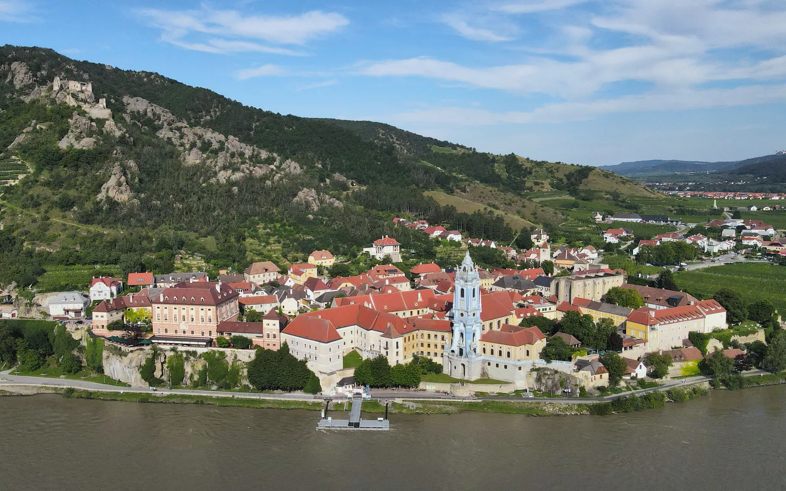 หมู่บ้าน Dürnstein สีฟ้าขาวริมแม่น้ำดานูบ ซากปราสาทบนยอดเขาเหนือหมู่บ้าน ไร่องุ่นปกคลุมเนินเขาโดยรอบ