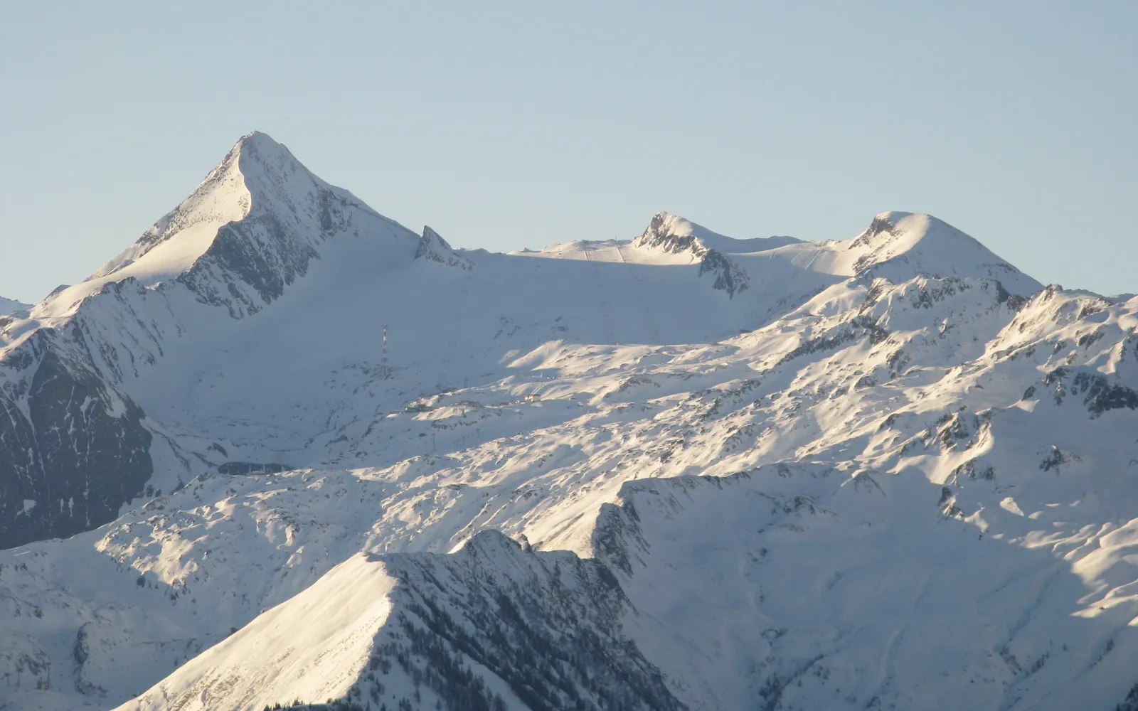 ธารน้ำแข็งบนยอดเขา Kitzsteinhorn สีขาวเงินจ้า กระเช้าไฟฟ้าสีแดงลอยตัดกับฟ้าสดใส
