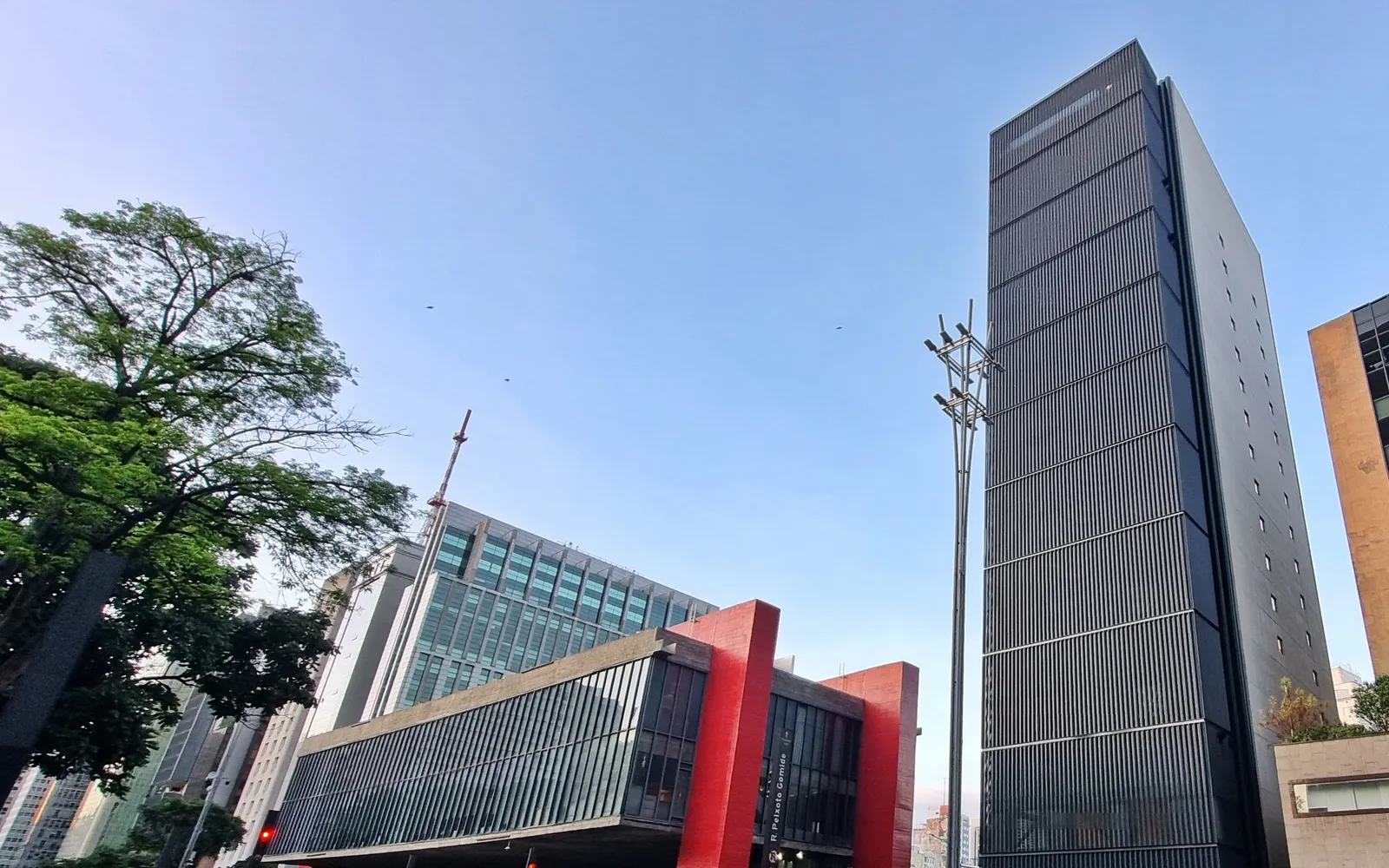 อาคาร MASP สีแดงลอยตัวเหนือเสาคอนกรีตบนถนนเปาลิสตา