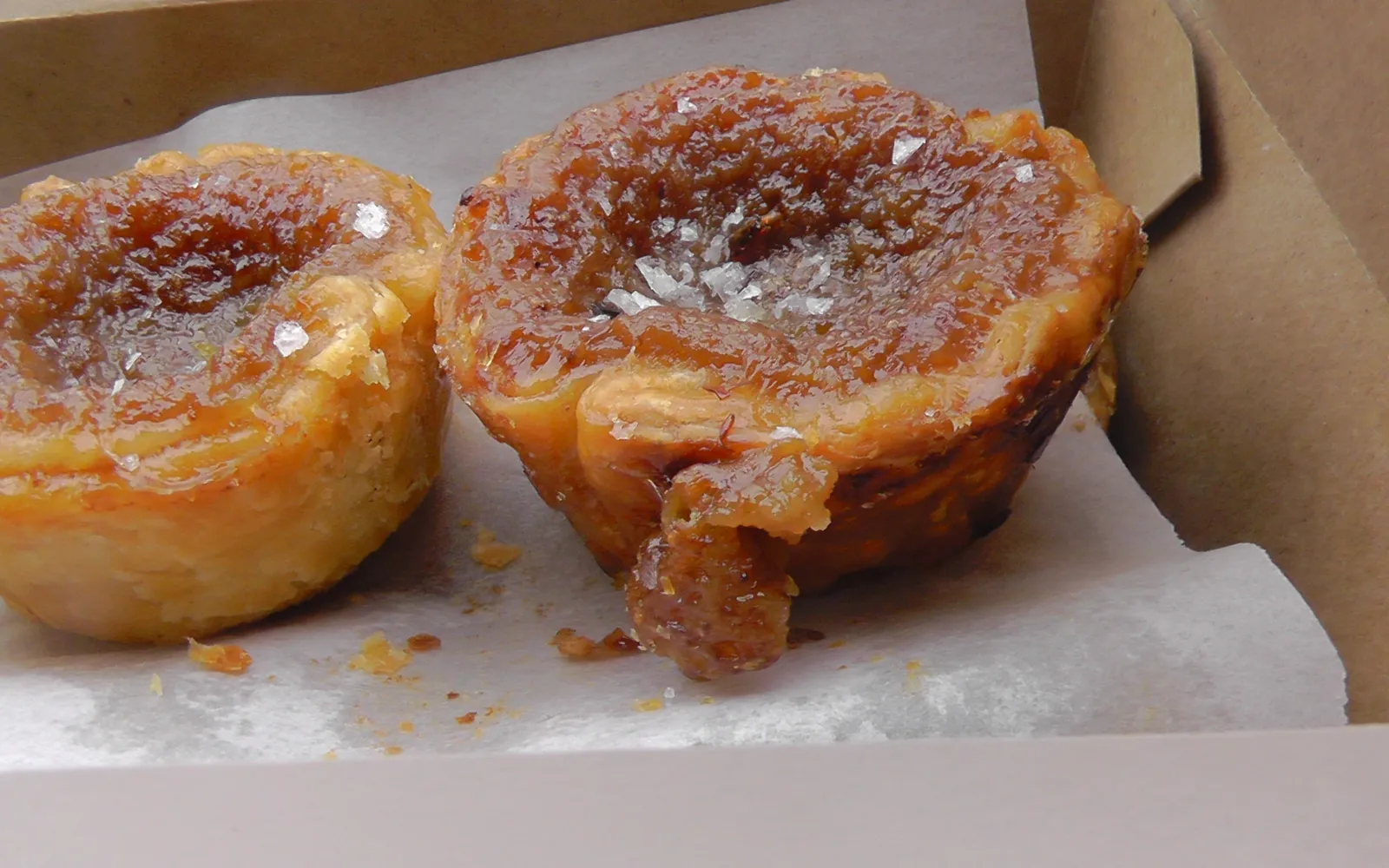 Butter tart แคนาเดียน เปลือกพายกรอบบางสีทองใส่ไส้เนยน้ำตาลเหลวข้นหวานหอม บนถาดไม้สีขาว