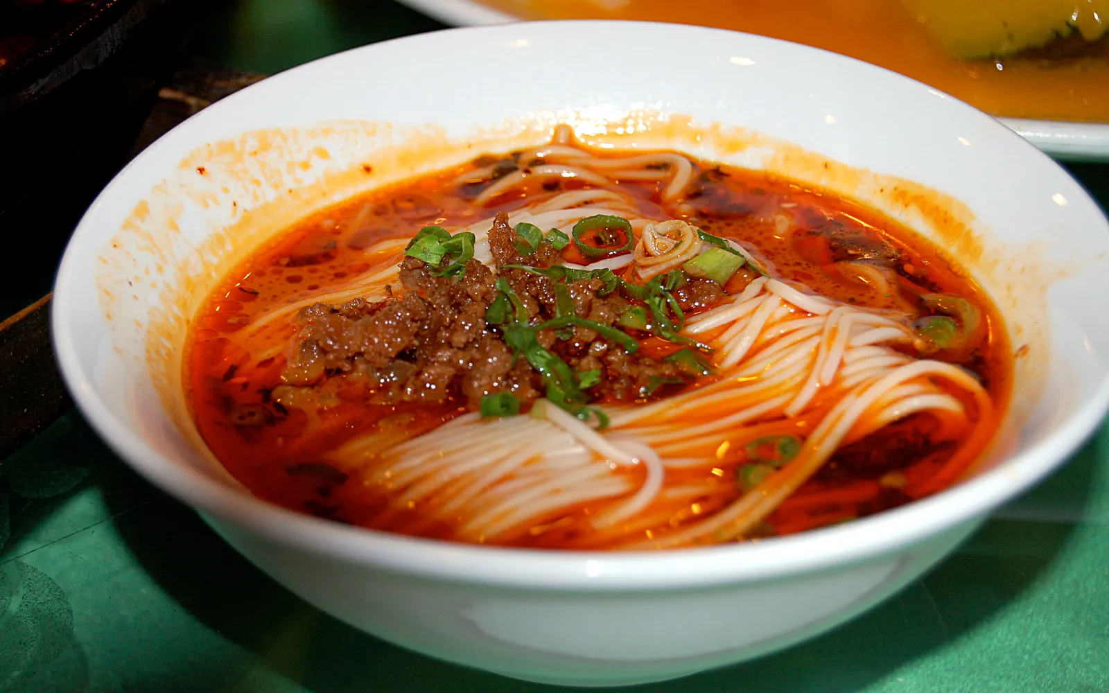 ก๋วยเตี๋ยวตั้นตั้นราดน้ำจิ้มพริกแดงและเนื้อสับในชามเล็ก