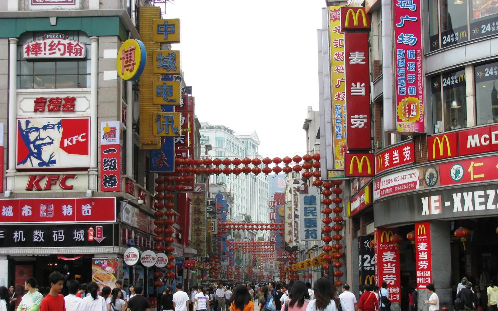 ถนนคนเดินซ่างเซี่ยจิ่วยามค่ำคืนเต็มไปด้วยร้านค้า แผงอาหาร และนักท่องเที่ยวท่ามกลางอาคารสไตล์ Tong Lau