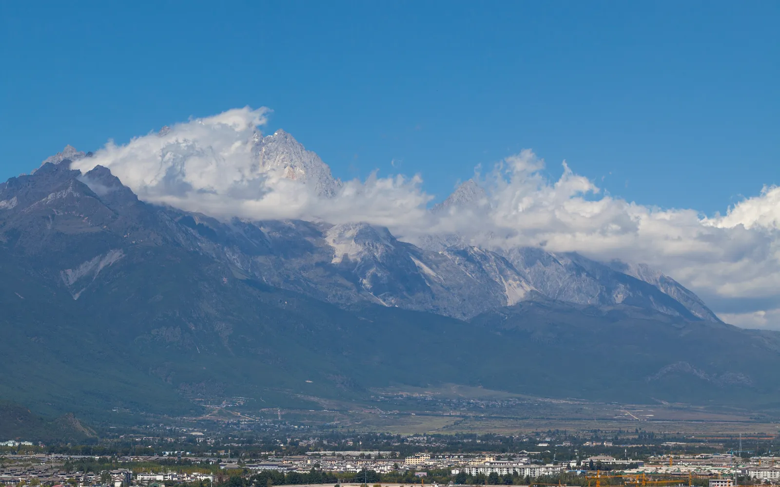 ยอดเขาหิมะขาวโพลนของ Jade Dragon Snow Mountain ใต้ท้องฟ้าสีคราม