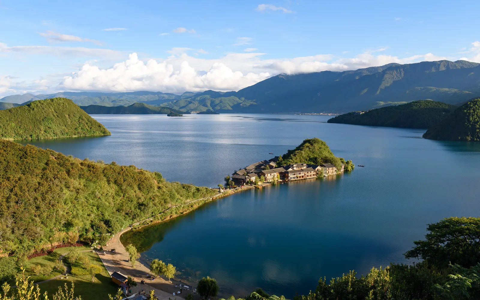 ทะเลสาบลูกูน้ำใสสีฟ้าครามและเรือไม้ไผ่ของชาวโมซัว มณฑลยูนนาน