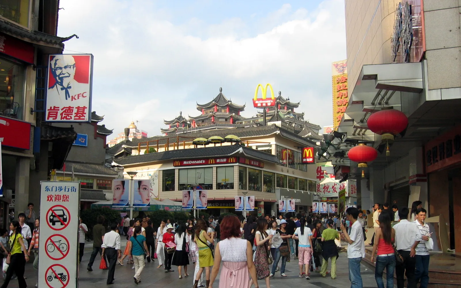 ถนนคนเดินต้งเหมินเซินเจิ้น ยามค่ำไฟสว่าง ผู้คนและร้านค้าเรียงรายสองข้างทาง