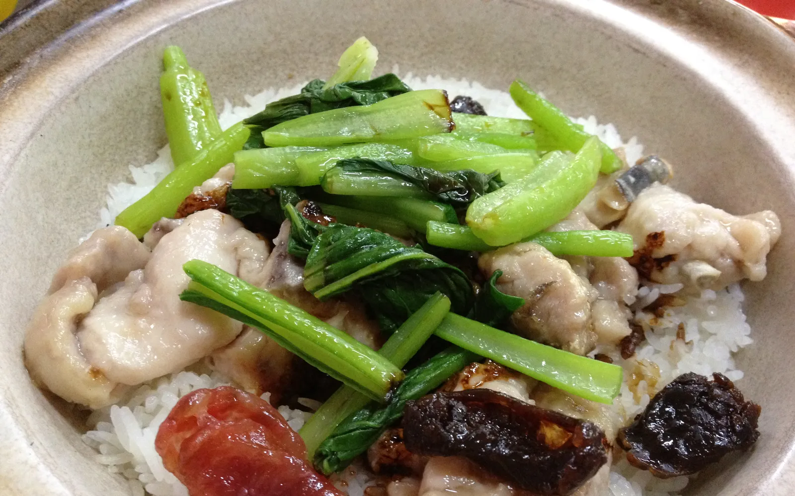 ข้าวหม้อดินกวางตุ้งพร้อมไส้กรอกลาป กระเทียม และซอสถั่วเหลือง เสิร์ฟในหม้อดินสีเข้ม