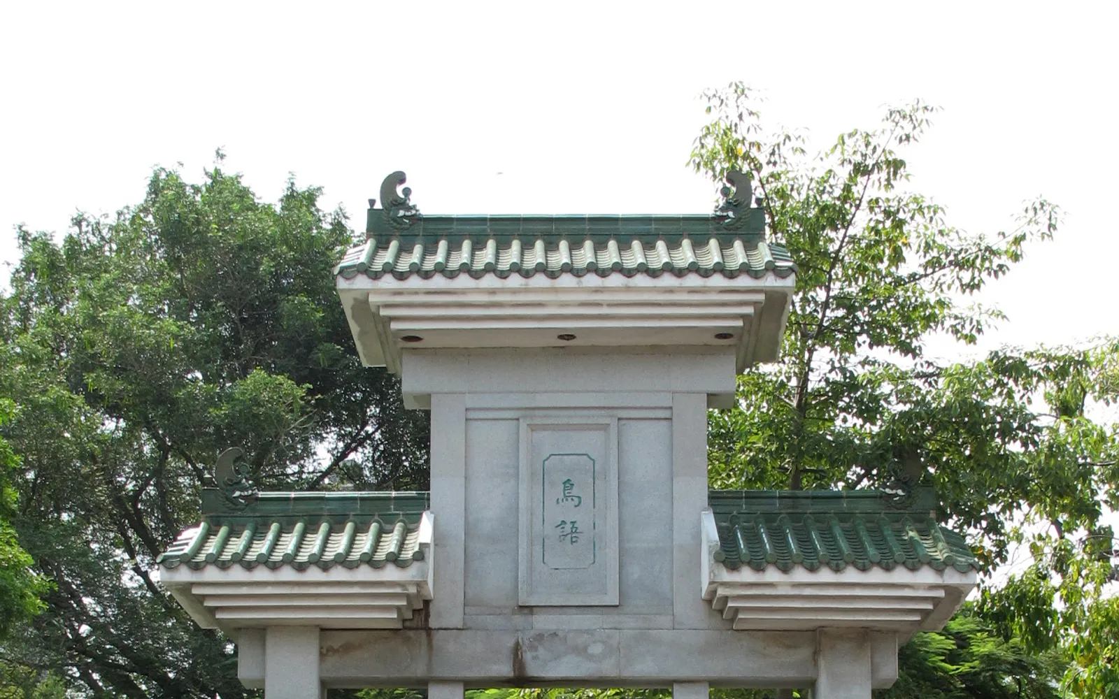 ผู้สูงอายุนั่งเลี้ยงนกในกรงไม้แกะสลักสวยงามในสวนนก Yuen Po Street