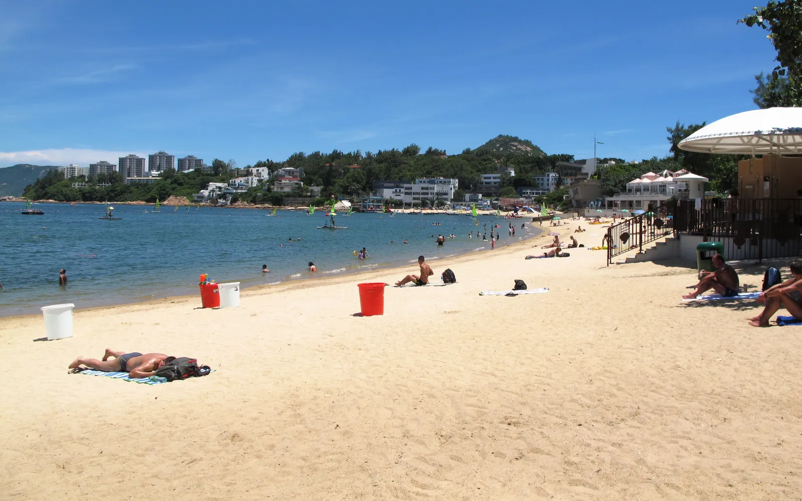 ชายหาดทรายขาวของสแตนลีย์พร้อมนักท่องเที่ยวเล่นน้ำและเล่นวินด์เซิร์ฟ