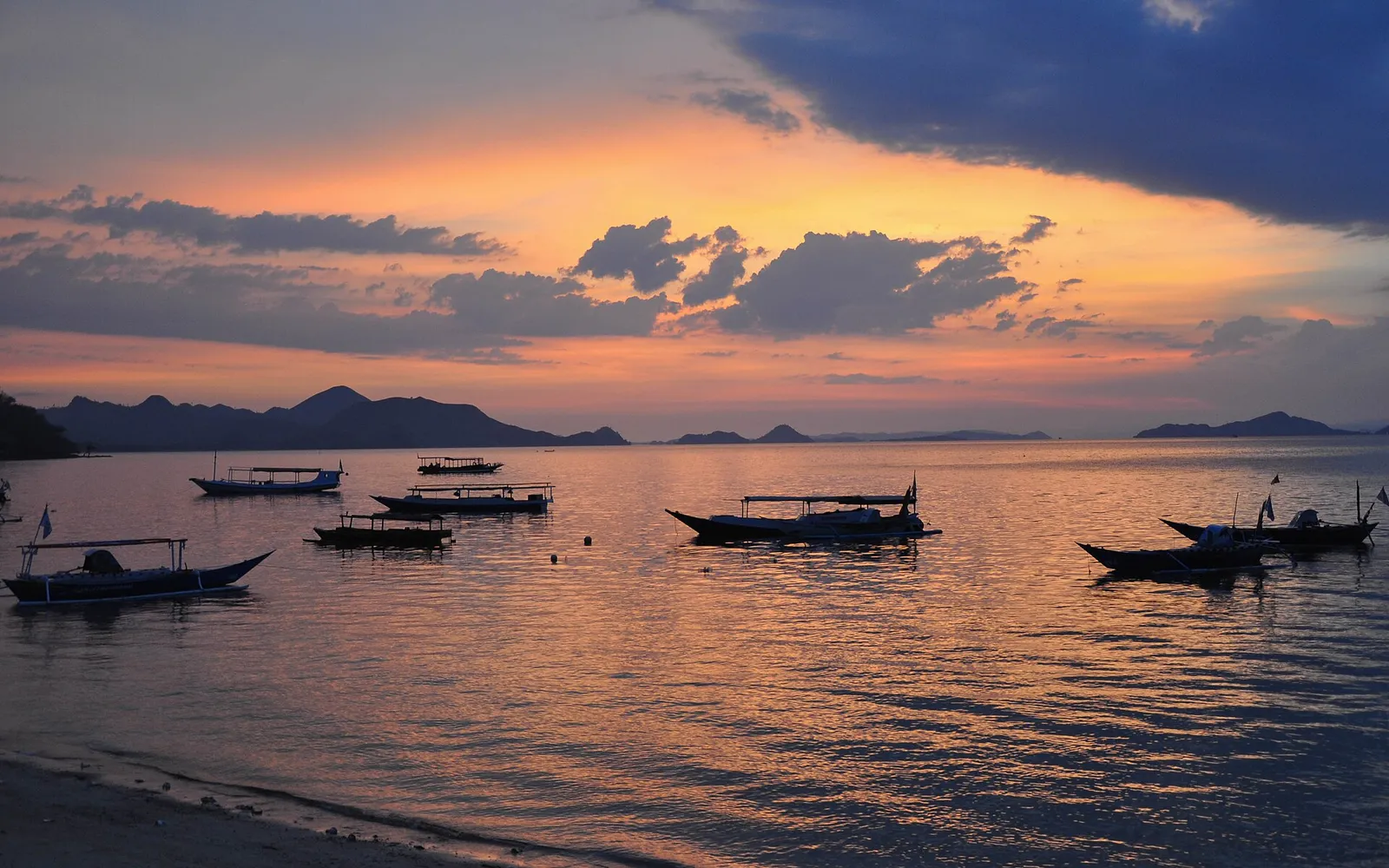 ชายหาดทรายขาวเงียบสงบของเกาะกานาวา มีน้ำทะเลใสสีฟ้าอมเขียวและแนวปะการังชายฝั่ง
