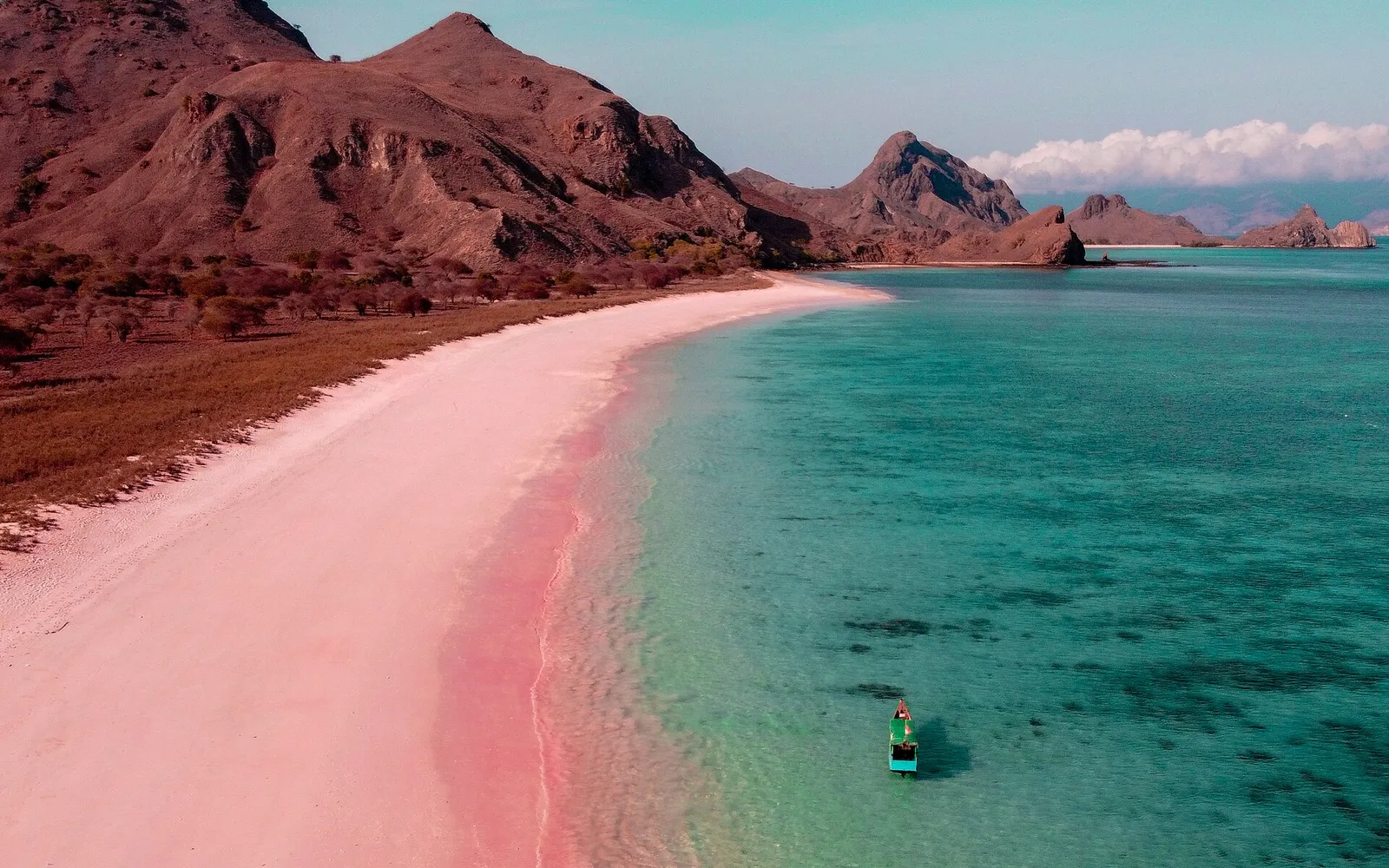 ชายหาดทรายสีชมพูอมแดงของ Pink Beach บนเกาะโกโมโด มีน้ำทะเลใสสีฟ้าคราม