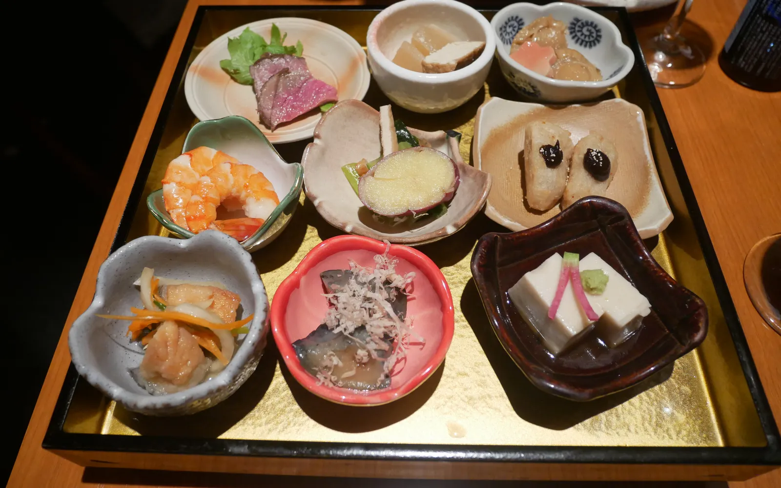 อาหาร Obanzai เกียวโต ถาดเล็กหลายใบเรียงผักดอง เต้าหู้ ปลาต้ม และอาหารบ้านเกียวโต