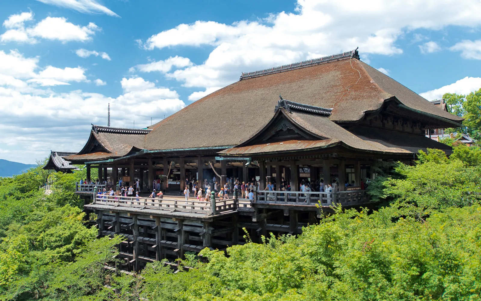ระเบียงไม้ขนาดใหญ่ของวัด Kiyomizudera ยื่นออกจากหน้าผาพร้อมวิวของเกียวโตเบื้องล่าง
