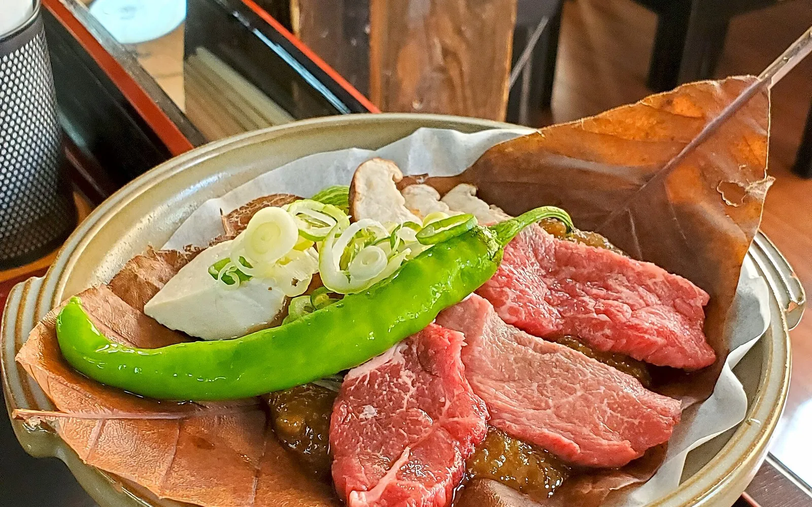 มิโสะและเนื้อวากิวฮิดะย่างบนใบโฮโนกิขนาดใหญ่บนเตาถ่านโต๊ะ