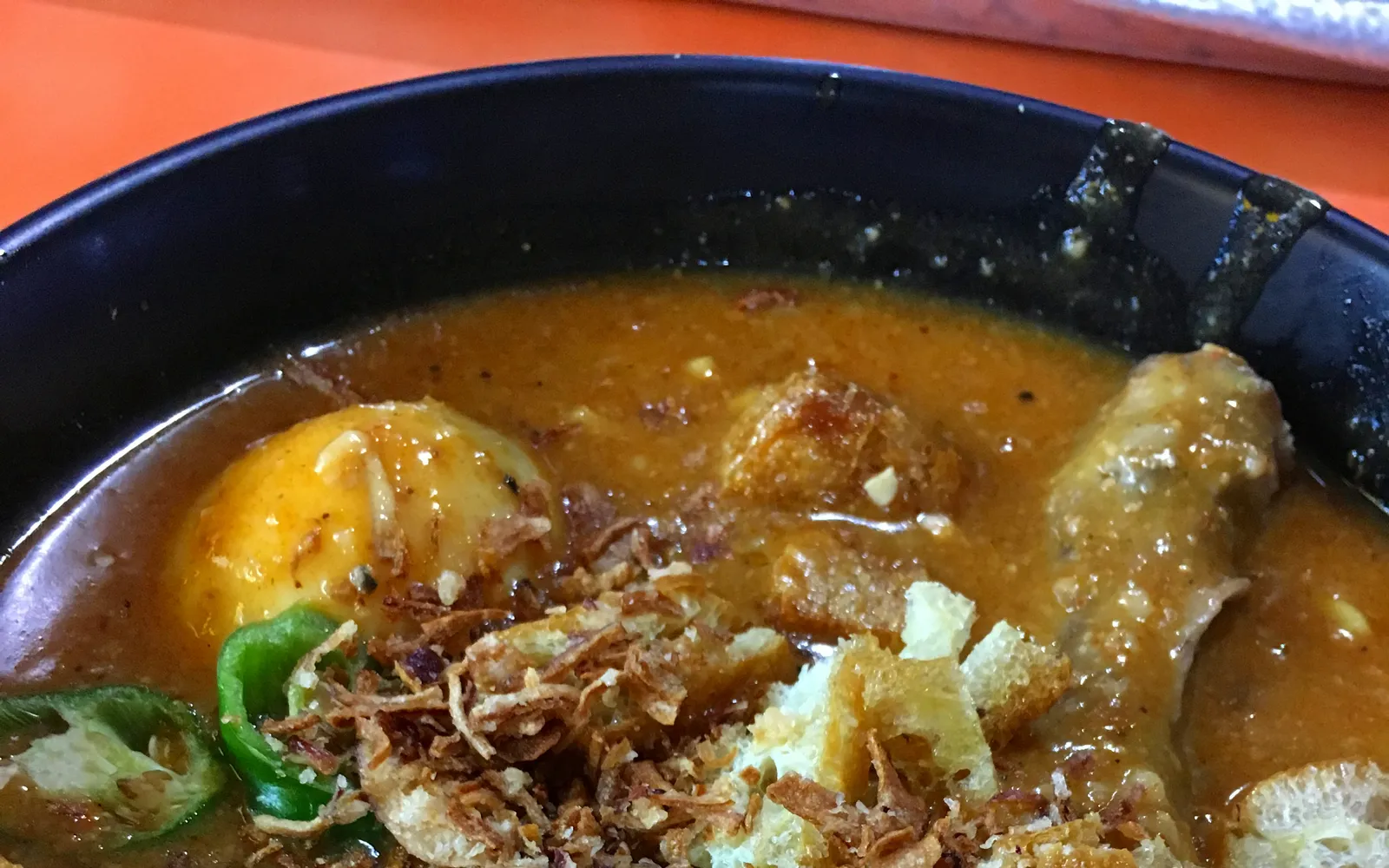 มีรีบุสเส้นเหลืองในน้ำแกงมันเทศเข้มข้น ราดด้วยถั่วงอก ไข่ต้มและหัวหอมทอด