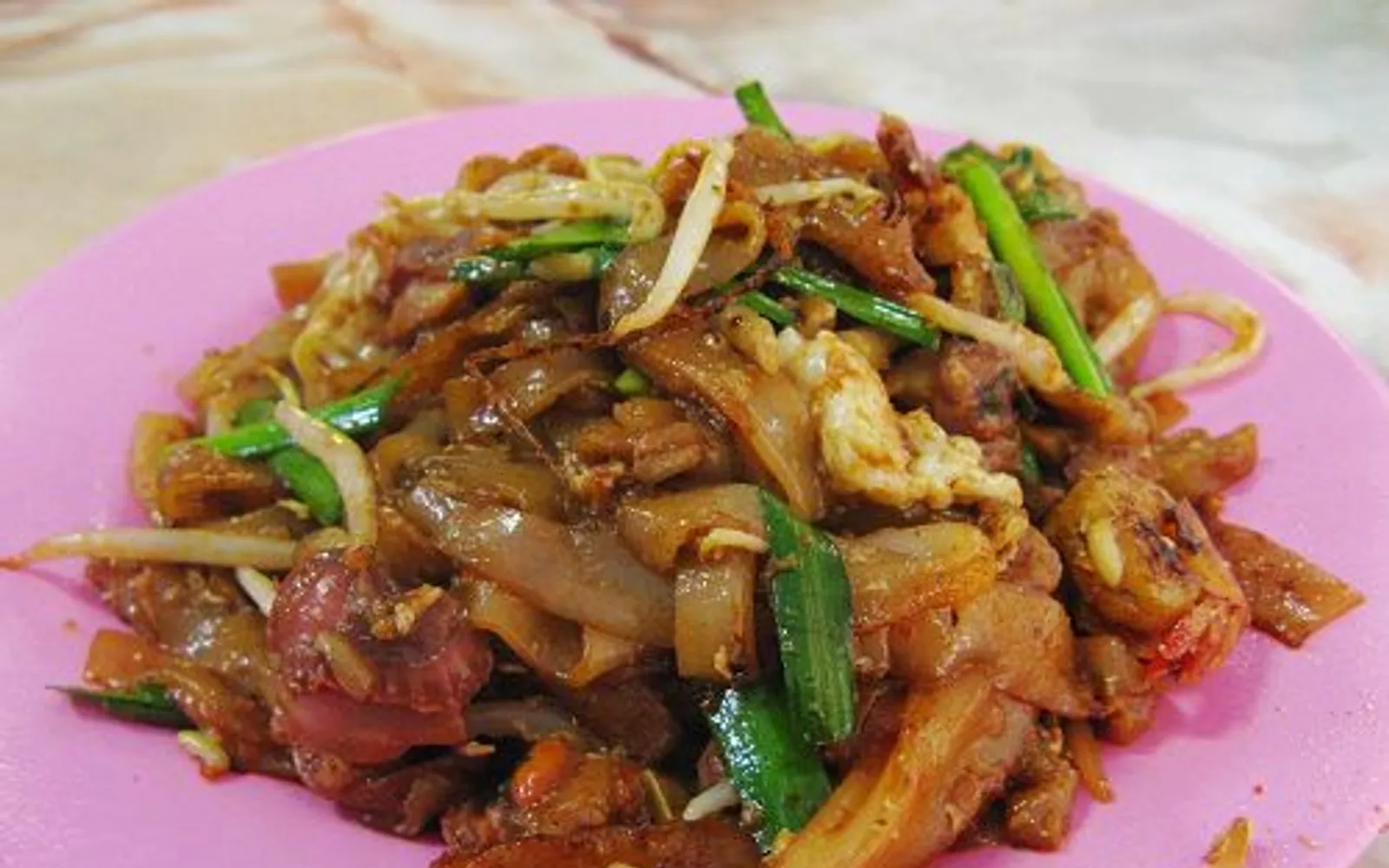 ก๋วยเตี๋ยวผัดชาร์กวยเตี๋ยวสีเข้มหอมกลิ่นควันจากกระทะเหล็กบนเตาแก๊สร้อนจัด