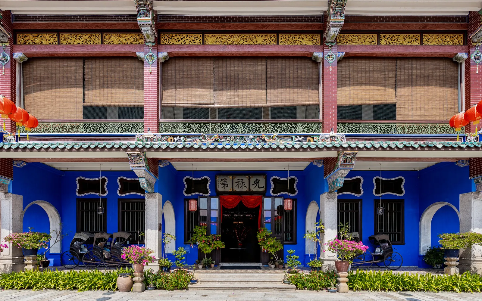 คฤหาสน์ชีองฟัตซีหรือบ้านสีน้ำเงินในจอร์จทาวน์ ผนังสีครามเข้มโดดเด่นตัดกับประตูไม้แกะสลักสีทอง