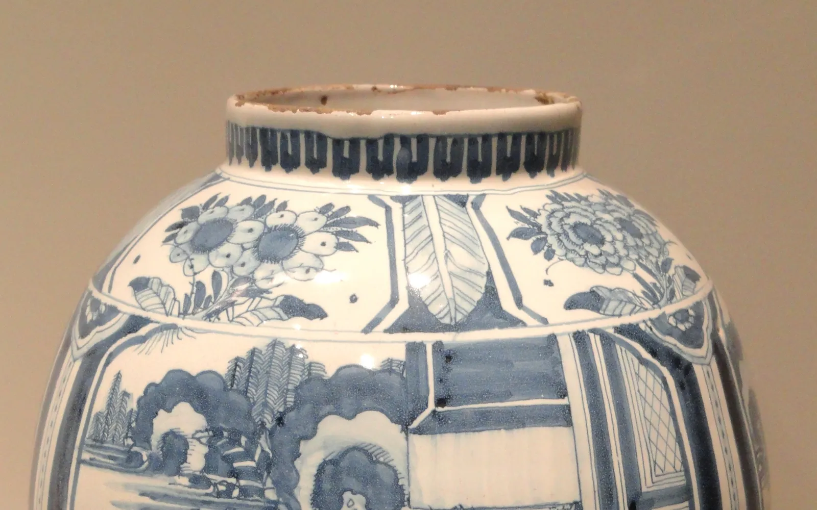 ช่างฝีมือ Royal Delft วาดลายสีน้ำเงินบนเครื่องเคลือบขาวด้วยมือ ขวดแจกันและจานหลากขนาดเรียงอยู่บนโต๊ะทำงาน