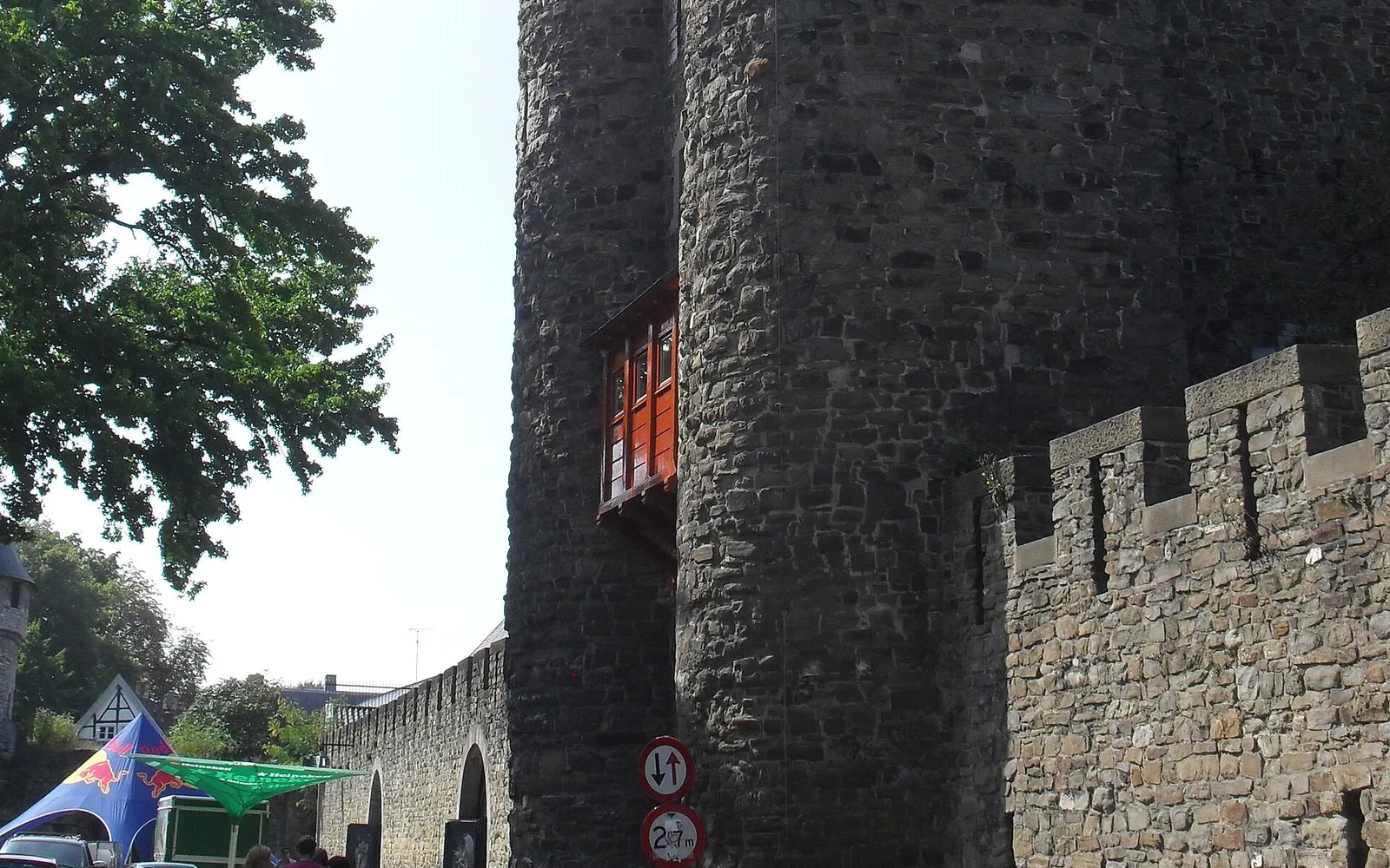 ประตูเมืองหินทรายขาว Helpoort มาสทริชต์ อายุกว่า 700 ปี โค้งรูปวงกลมสูง ต้นไม้เลื้อยปกคลุมบางส่วน ริมลำน้ำเจเกอร์