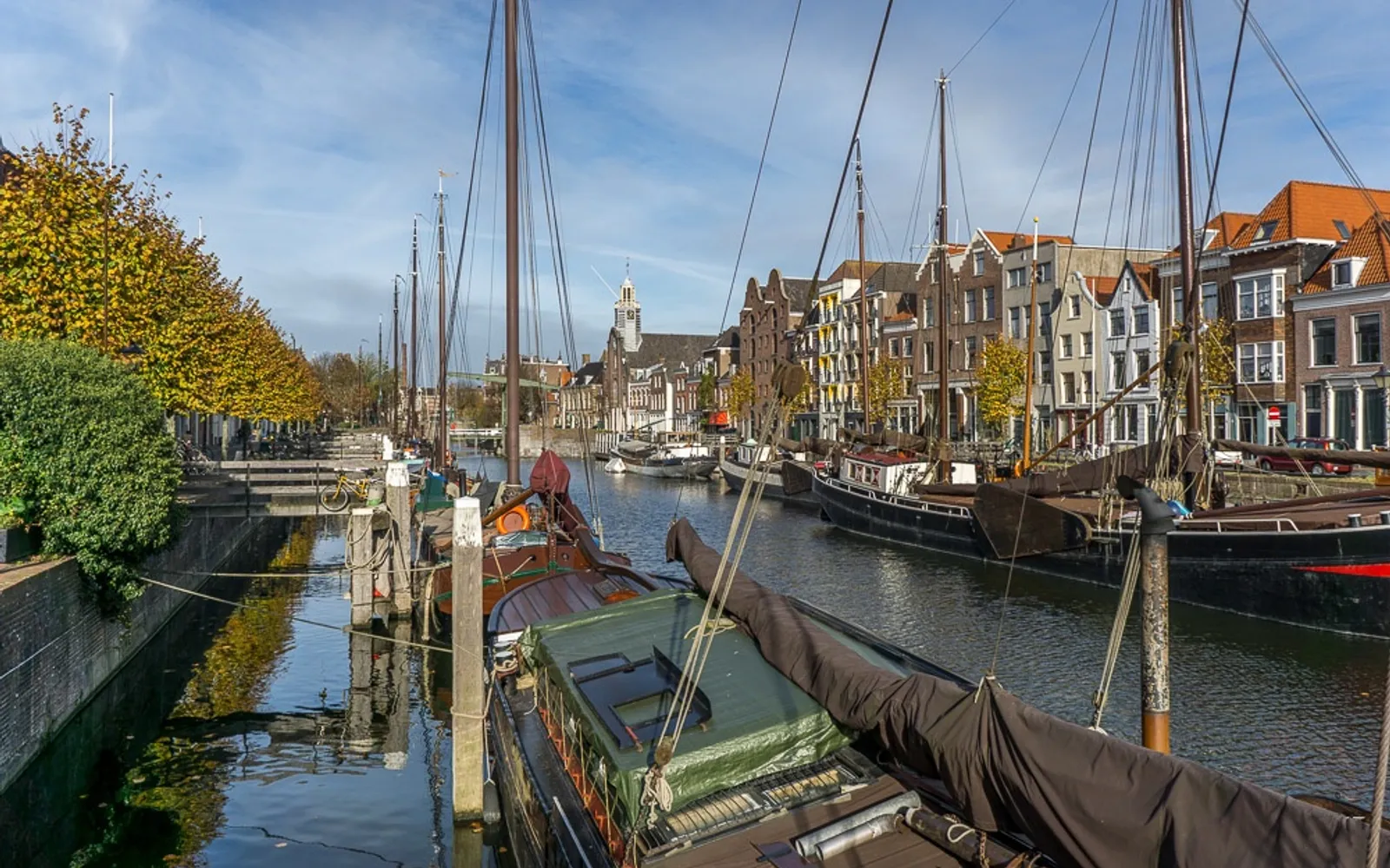 ย่าน Delfshaven รอตเตอร์ดัม บ้านทรงเฮาส์เก่าแก่สไตล์ดัตช์สะท้อนลงคลองสงบเงียบ กังหันลมเก่าตั้งอยู่ปลายถนน