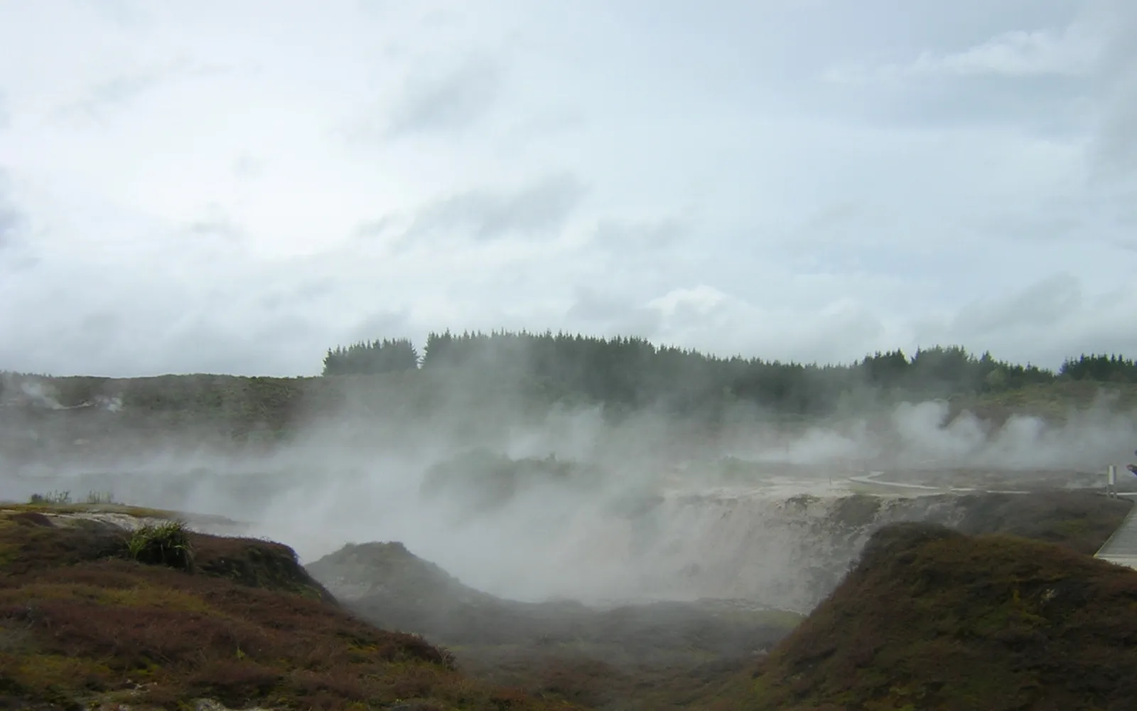 หลุมน้ำพุร้อนและไอน้ำพวยพุ่งขึ้นจากพื้นดินสีเทาแห้งแล้งที่ Craters of the Moon ใกล้เทาโป ทิวทัศน์แปลกตาเหมือนดาวอื่น