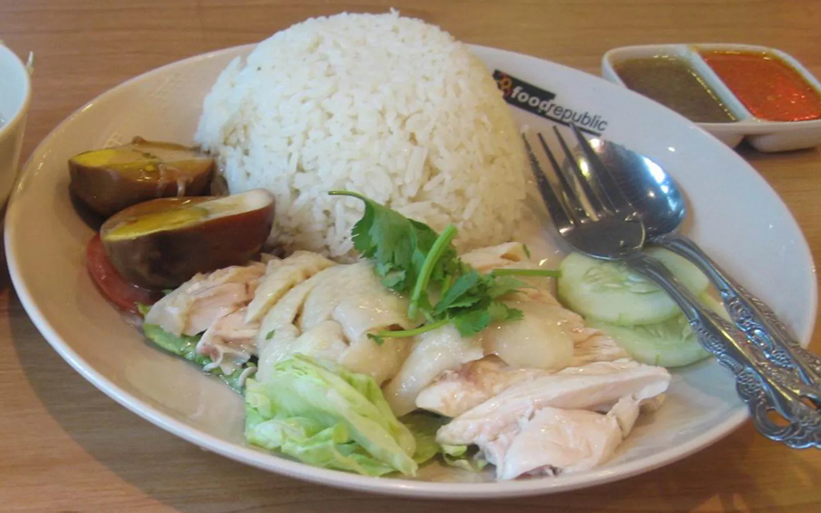 จานข้าวมันไก่ไหหลำสิงคโปร์พร้อมไก่ต้มสีทองนุ่ม น้ำซุปใสร้อน และซอสพริกสามอย่าง