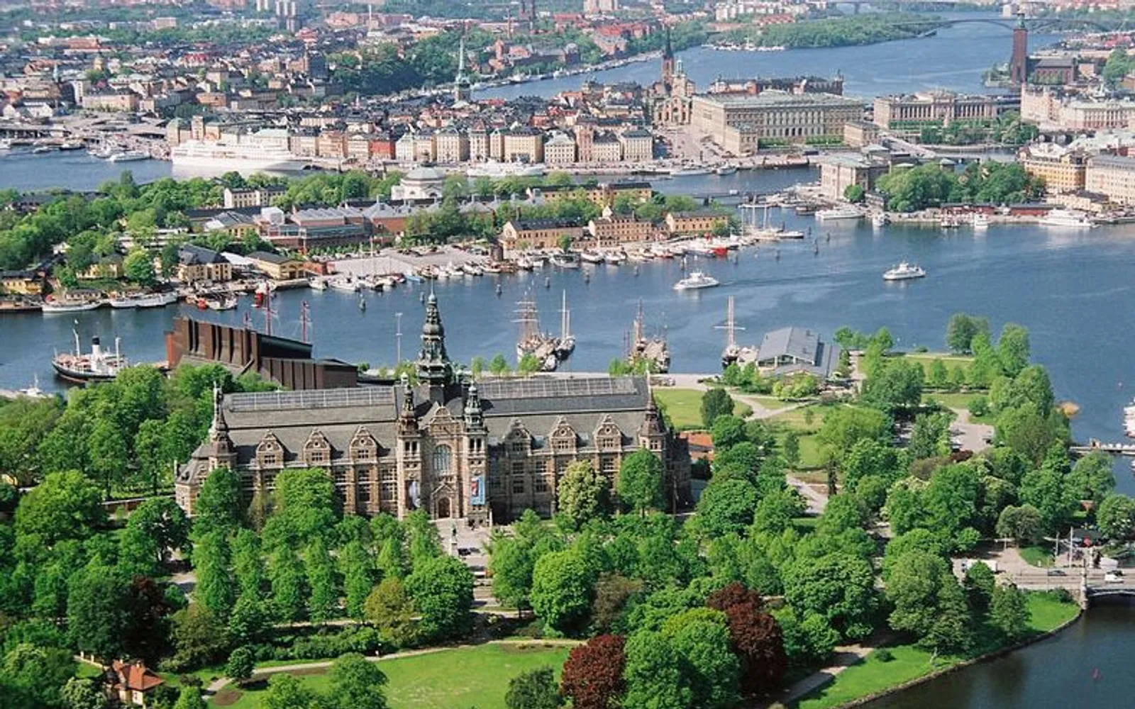 ทางเดินเลียบน้ำและต้นไม้เขียวขจีบนเกาะ Djurgården สตอกโฮล์ม