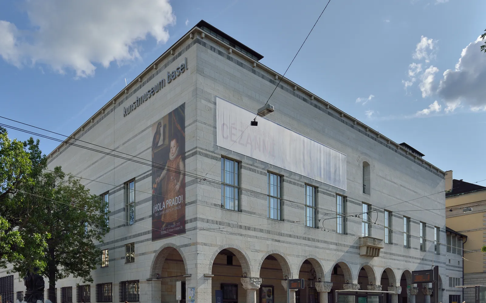 อาคารหินทรายเทาของ Kunstmuseum Basel ประตูสูงโค้งแบบโมเดิร์น รูปปั้นหน้าทางเข้าบนบันไดกว้าง