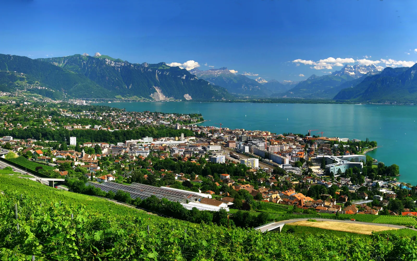 จัตุรัสกลางเมือง Vevey ริมทะเลสาบเลมัน รูปส้อมยักษ์สตีลโผล่ขึ้นจากน้ำเป็นแลนด์มาร์กสุดพิเศษ เทือกเขาแอลป์เป็นฉากหลัง