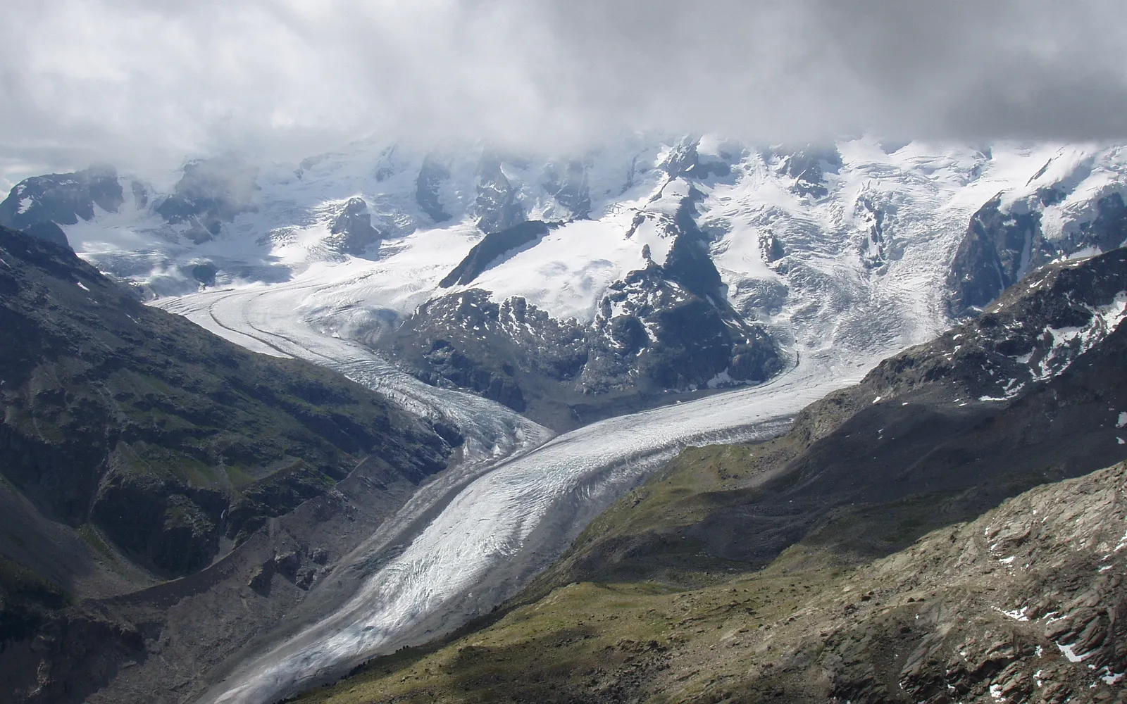 ธารน้ำแข็ง Morteratsch สีขาว-น้ำเงินเทาทอดยาวลงมาจากยอดเขา Piz Bernina สูง 4,049 เมตร เส้นทางเดินตีนธารน้ำแข็งชัดเจนท่ามกลางหินสีเทา