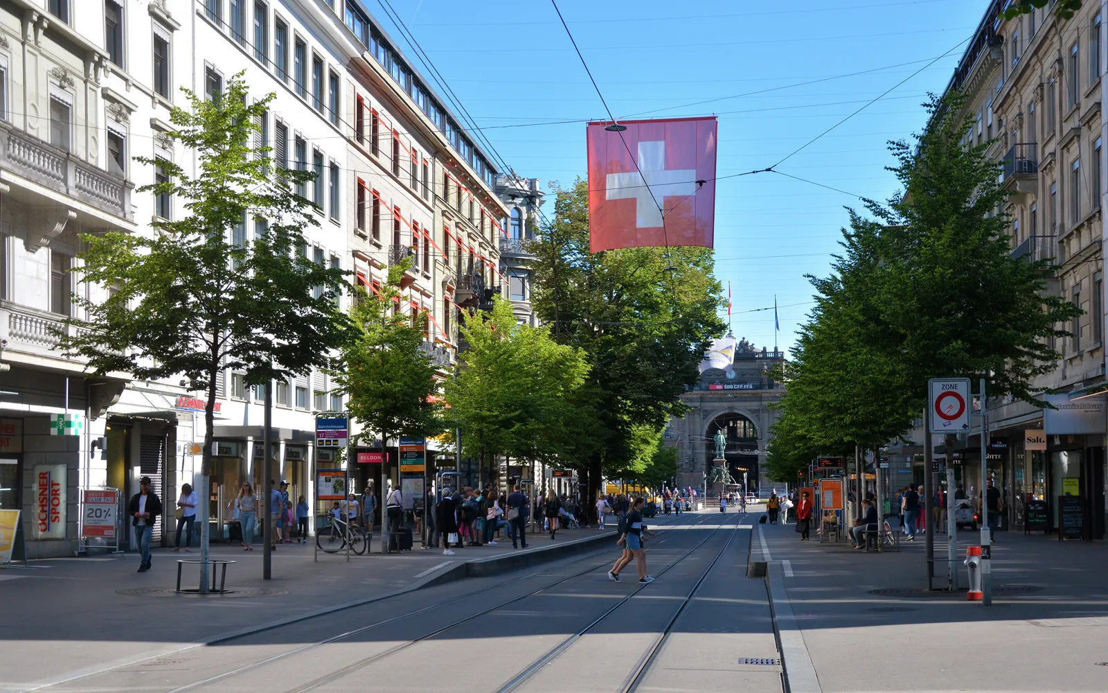 ถนน Bahnhofstrasse ซูริค เส้นทางกว้างปูด้วยหินแกรนิต ต้นสนปลูกเรียงสองข้าง ร้านค้าแบรนด์หรูและธนาคารชั้นนำตลอดแนว