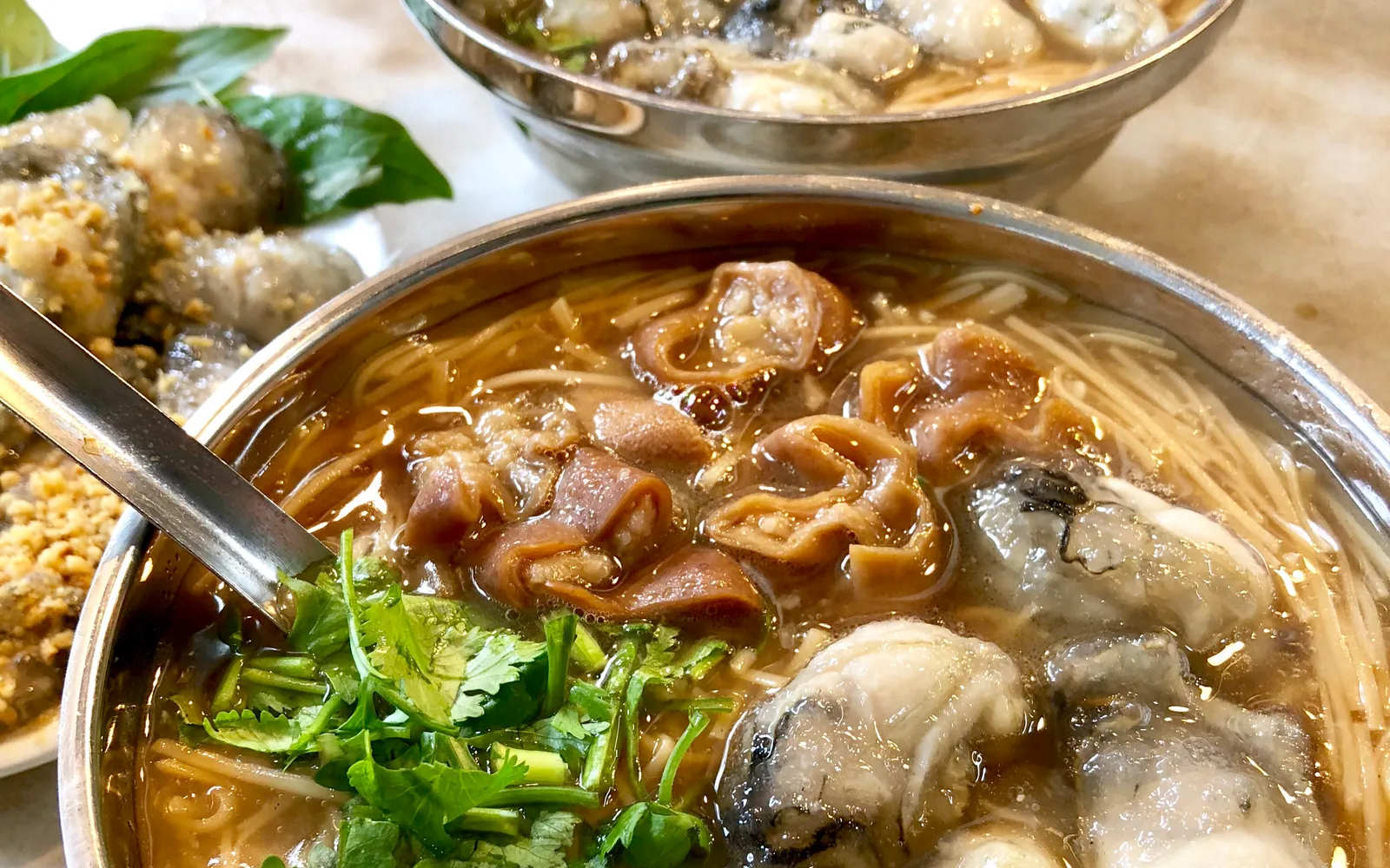 ชามเส้นหมี่หอยนางรมในน้ำซุปข้นสีน้ำตาลกลมกล่อม