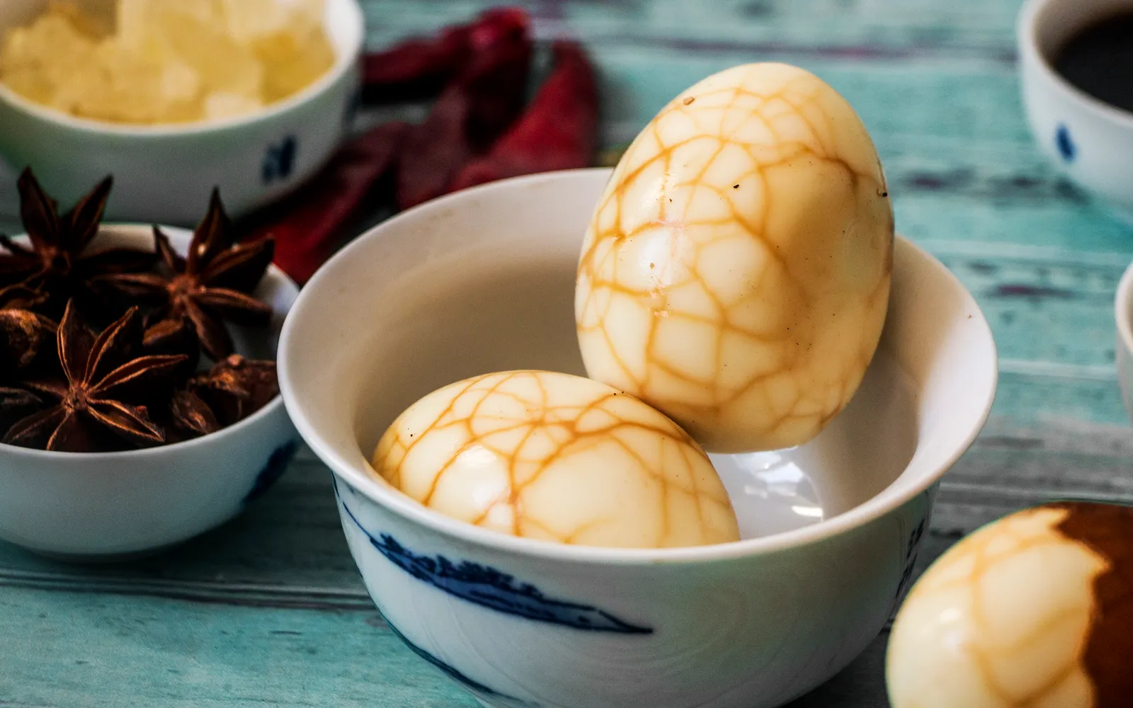 ไข่ชาสีน้ำตาลเข้มลวดลายหินอ่อน เสิร์ฟในถาดไม้พร้อมซอสพิเศษ