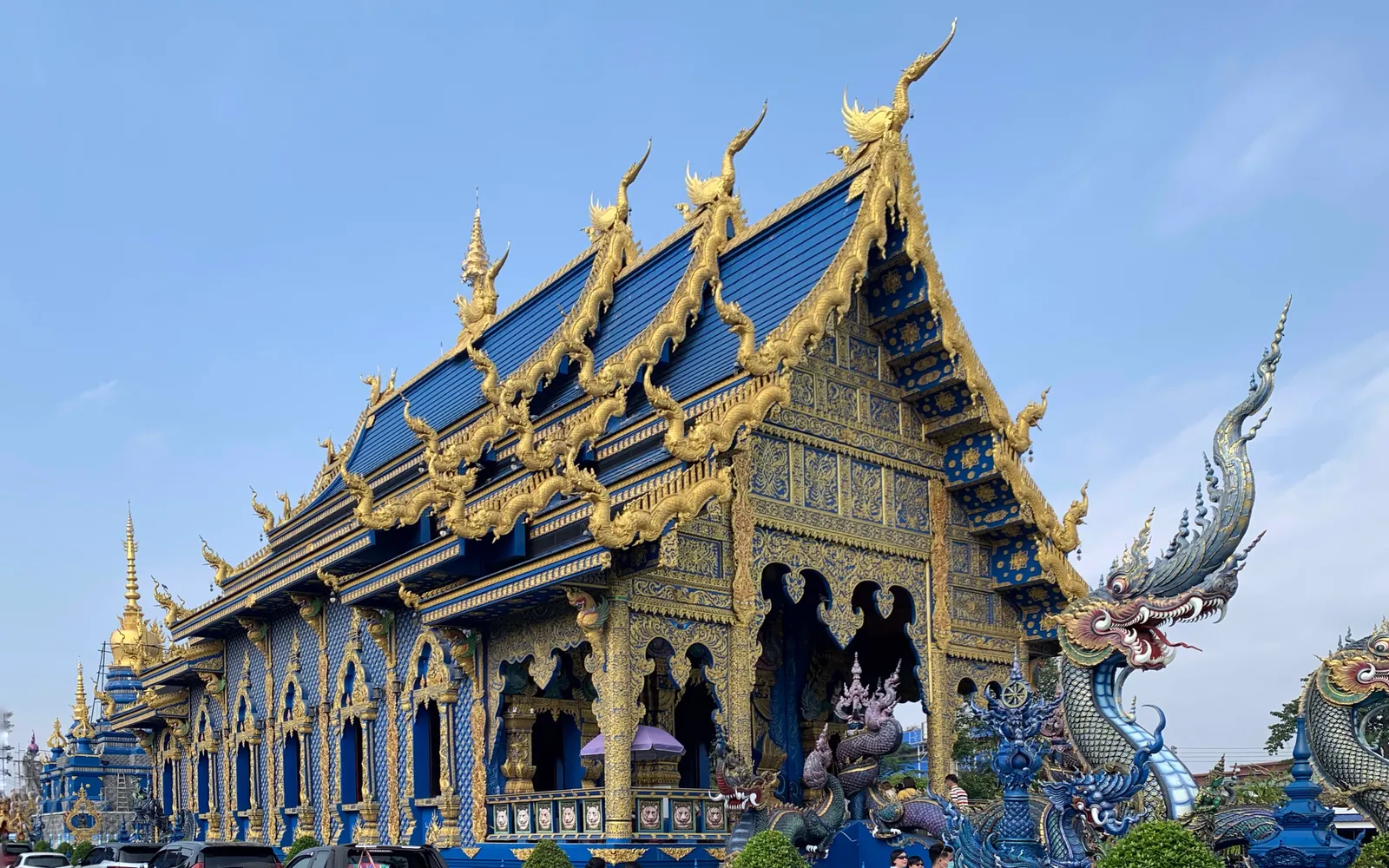 วัดร่องเสือเต้นยามค่ำคืน วิหารสีน้ำเงินเข้มประดับทองสว่างไสว องค์พระพุทธรูปสีขาวนวลตั้งโดดเด่น