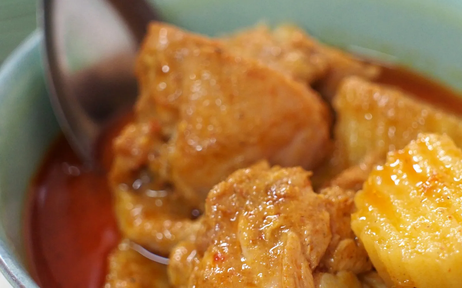 แกงมัสมั่นไก่กระบี่ในถ้วยดินเผา น้ำแกงสีน้ำตาลทองเข้ม มีมันฝรั่งและถั่วลิสง