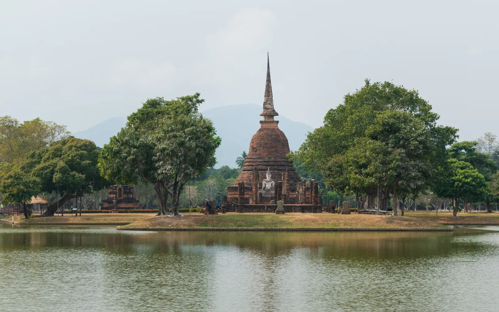 เจดีย์ทรงระฆังของวัดสระศรีตั้งบนเกาะกลางสระตระพังตระกวน เงาสะท้อนบนผิวน้ำนิ่ง