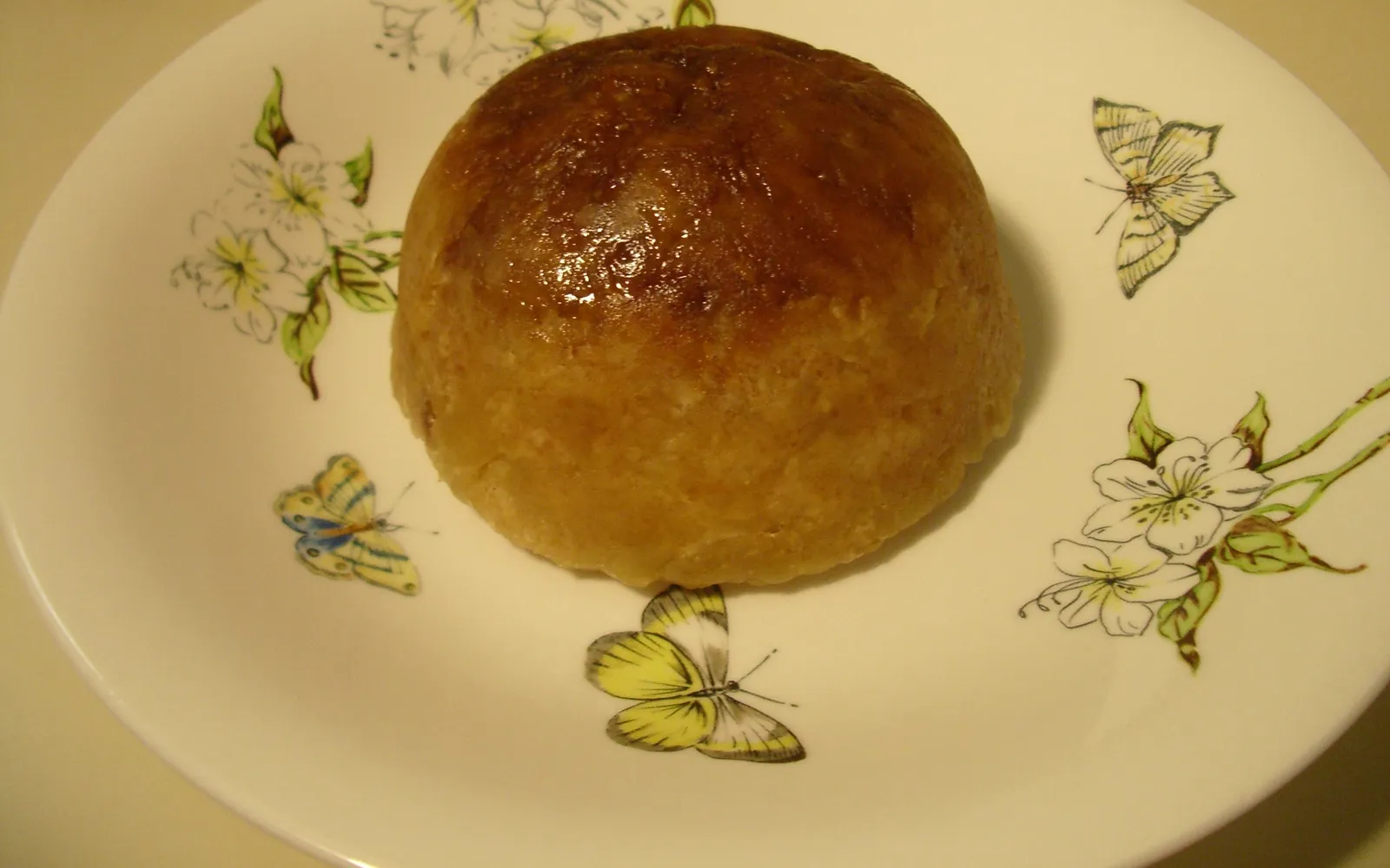 Sussex Pond Pudding นึ่งในชามขาว เนยและน้ำตาลละลายไหลออกมาเป็นซอสสีทองข้น ตัดกับผิวขนมปังนุ่มสีน้ำตาลอ่อน