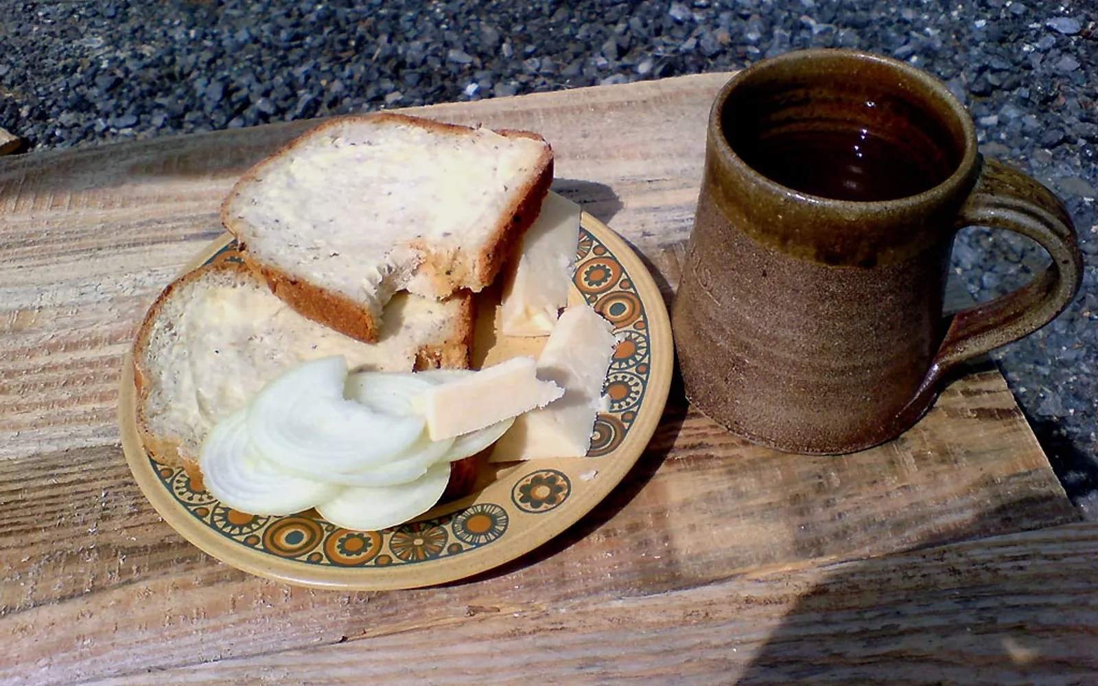Ploughman's Lunch จานไม้ขนาดใหญ่บนโต๊ะผับ มีขนมปังกรอบ ชีส cheddar หั่นหนา Branston pickle สีน้ำตาล แฮมหั่น แอปเปิ้ลแดง และผักดอง เสิร์ฟบนเขียงไม้