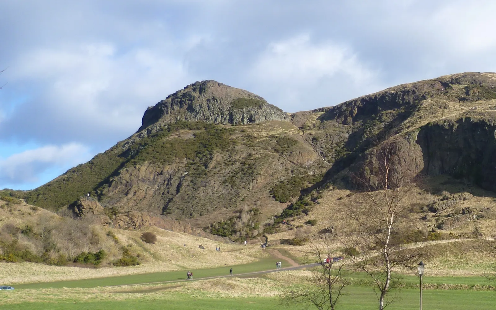 ยอดเขา Arthur's Seat ในเอดินบะระ เนินหญ้าเขียวสลับหินภูเขาไฟสีเทาโผล่ขึ้นกลางเมือง มองจากยอดเห็นเส้นขอบฟ้าทั้งเมืองและอ่าวทะเลสีน้ำเงิน