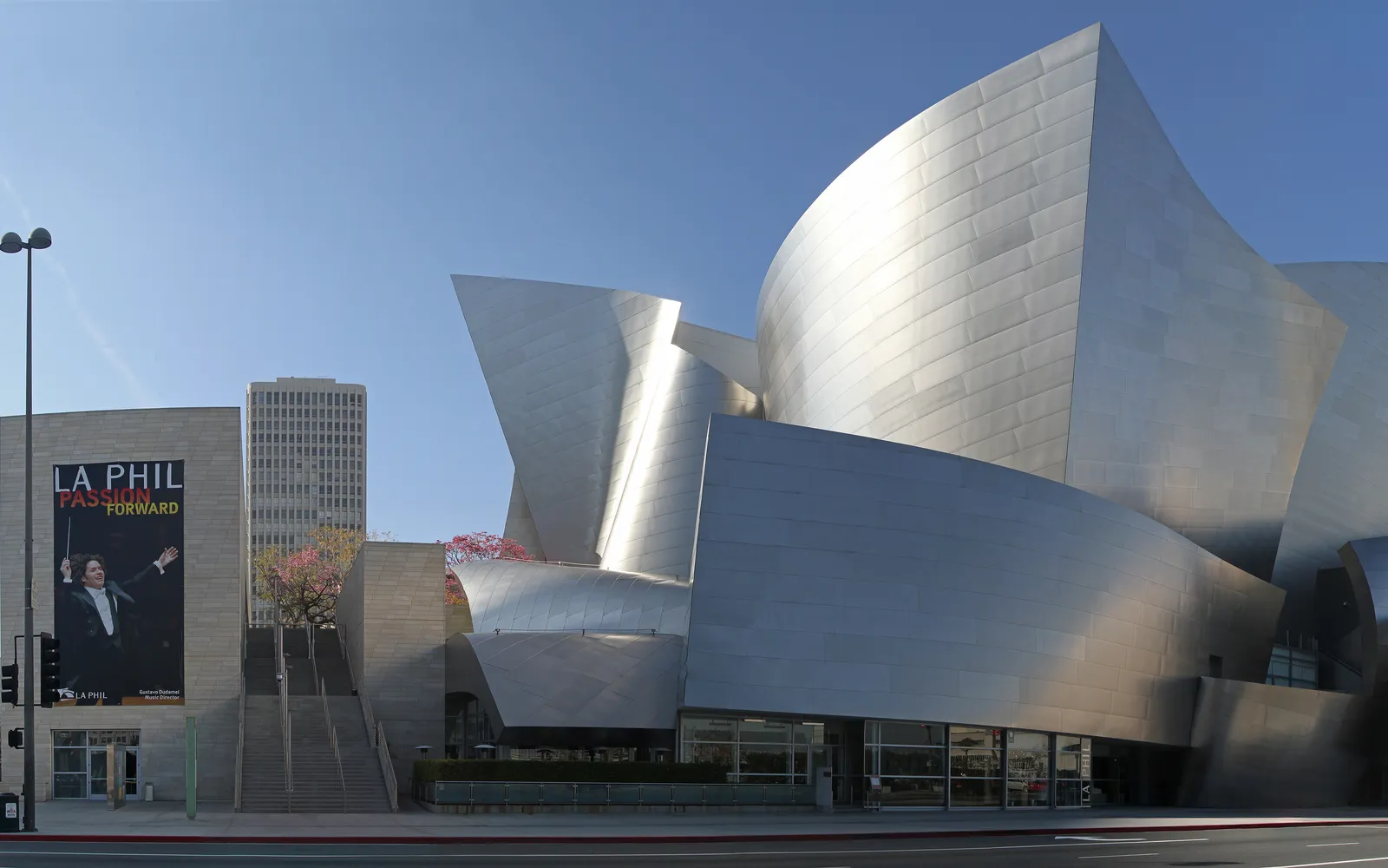 อาคาร Walt Disney Concert Hall โค้งเว้าสะท้อนแสงโลหะสีเงินบิดไปมาอย่างอิสระ ตัดกับท้องฟ้าสีฟ้าใสของลอสแอนเจลิส
