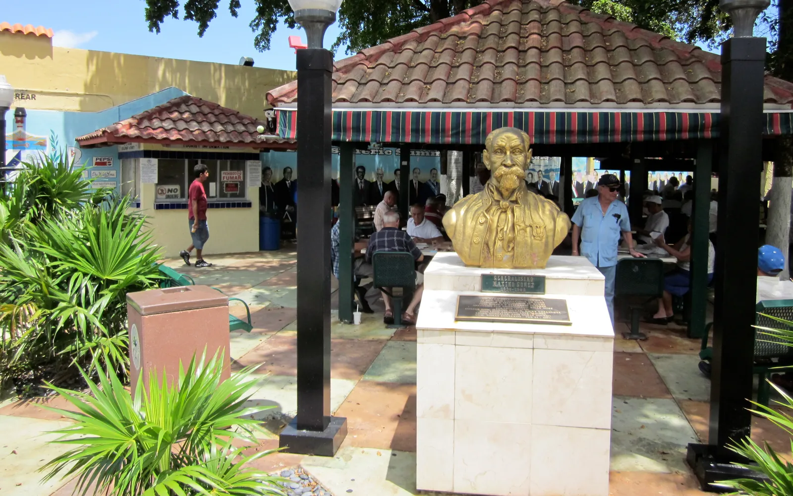 ถนน Calle Ocho ในย่านลิตเติ้ลฮาวานา ผู้สูงอายุชาวคิวบาเล่นหมากรุก ร้านค้าตกแต่งธงคิวบาและภาพจิตรกรรม เสียงดนตรีซัลซ่าดังออกมาจากร้านอาหาร