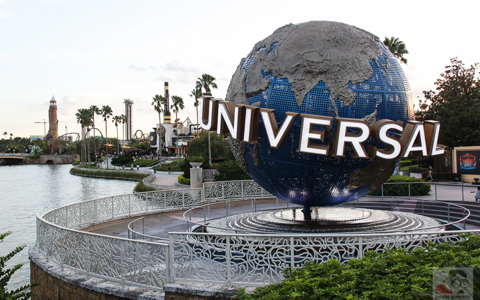 ลูกโลก Universal Studios ที่ทางเข้า Universal Orlando Resort ท่ามกลางนักท่องเที่ยวคึกคักและอาคารสูงของโรงแรมในเครือ