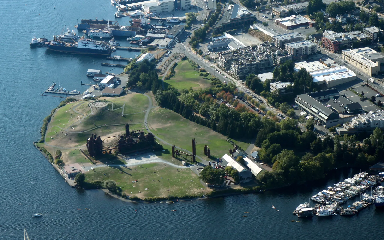 ซากอุตสาหกรรมสีสนิมของโรงงานแก๊สเก่าท่ามกลางสนามหญ้าเขียวของ Gas Works Park ริม Lake Union
