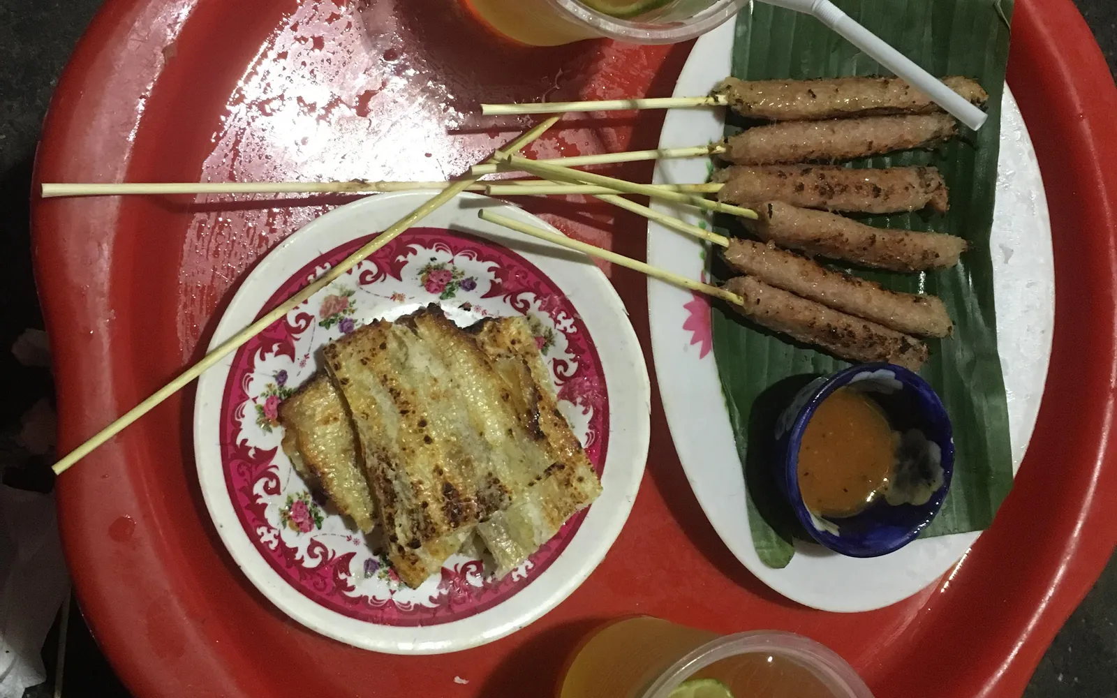 เน็มหลุ่ยไม้เสียบหมูสับปรุงรสเสียบตะไคร้ย่างถ่าน เสิร์ฟพร้อมผักสดและแผ่นข้าวเจ้าสำหรับห่อ